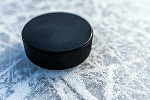 zwart hockey puck leugens Aan ijs Bij stadion foto