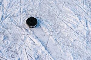 zwart hockey puck leugens Aan ijs Bij stadion foto