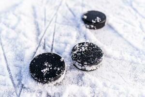 zwart hockey pucks leugens Aan ijs Bij stadion foto