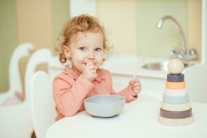 weinig baby eet pasta in de kinderen keuken foto