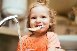 gelukkig lachend baby meisje poetsen haar tanden in de bad foto