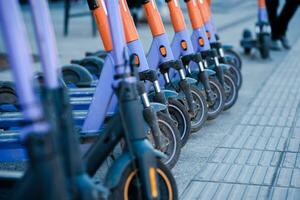 elektrisch scooters zijn geparkeerd in de stad centrum. modern openbaar mobiel vervoer foto