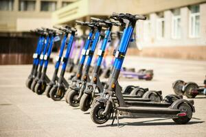 elektrisch scooters zijn geparkeerd in de stad centrum. modern openbaar mobiel vervoer foto