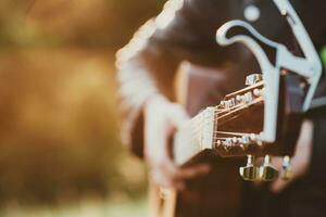 musicus Mens spelen gitaar Bij zonsondergang detailopname foto