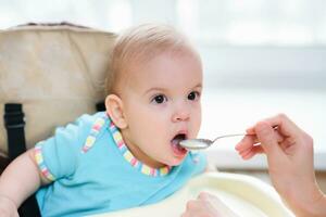 mam feeds haar negen maanden baby Bij huis foto