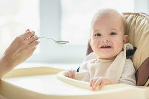 mam feeds haar negen maanden baby Bij huis foto