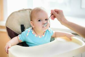 mam feeds haar negen maanden baby Bij huis foto