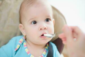 mam feeds haar negen maanden baby Bij huis foto