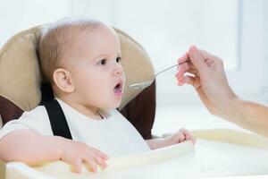 mam feeds haar negen maanden baby Bij huis foto