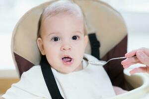 mam feeds haar negen maanden baby Bij huis foto