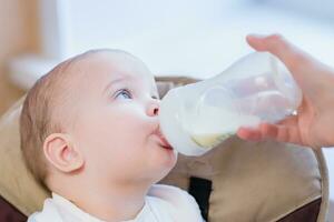 moeder feeds baby van een fles van melk foto