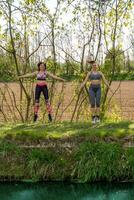 Dames rennen langs de banken van een kreek vervelend sportkleding foto