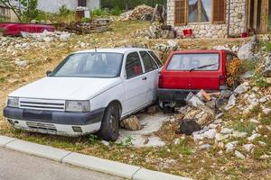 oude kapotte auto's geparkeerd in een chaotische tuin in novi vinodolski, kroatië foto