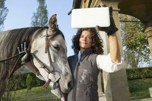 amazone duurt een selfie met zijn paard naar de land wegen in herfst foto