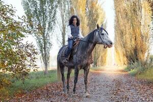 amazone ritten zijn paard naar de land wegen in herfst foto