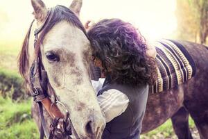 amazone omarmt zijn paard met genegenheid foto