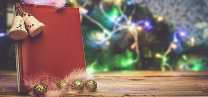 een groot Kerstmis wens boek met Kerstmis boom speelgoed en decoraties Aan houten tafel. een lezen leer kladblok - een geschenk voor Kerstmis of nieuw jaar foto