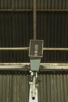 industrieel licht lamp in een beschermend draad kooi, gemonteerd Bij de metaal muur foto