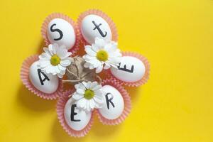 gelukkig Pasen. Pasen tekst Aan wit eieren met voorjaar bloemen foto