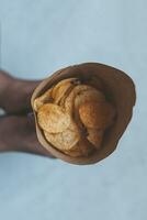 een papier ijshoorntje vol van aardappel chips Aan de marmeren foto