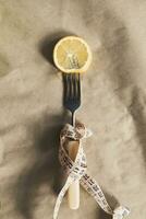 vers citroen plak Aan een vork met meten plakband. eetpatroon, gezond aan het eten concept. Aan bruin papier achtergrond foto