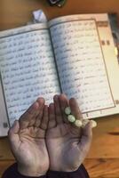 bidden jong moslim vrouw. midden- oostelijk meisje bidden en lezing de heilig koran. moslim vrouw aan het studeren de koran foto