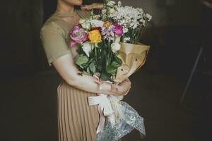 mooi midden Oosten meisje met een boeket van bloemen in handen. jong aantrekkelijk vrouw met bloemen. portret van charmant, mooi meisje Holding bloemen boeket foto