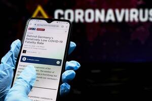 dokter controle nieuws Aan smartphone over covid-19 situatie in Duitsland foto