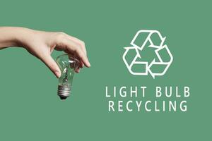 een persoon het werpen licht lamp voor recycling foto