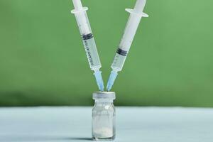 een covid-19 vaccin flacon met injectiespuiten foto