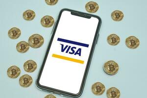 Visa logo app Aan mobiel telefoon scherm en bitcoins cryptogeld foto