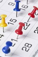 gekleurde Duwen pinnen Aan maandelijks kalender bladzijde foto