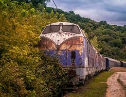 mooi wijnoogst blauw trein verlaten door de bossen foto