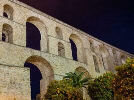 oude Romeins aquaduct, oranje bomen en palmen in voorkant van het - nacht schot - Kavala, Griekenland foto