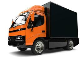 oranje klein doos vrachtauto met zwart aanhangwagen foto