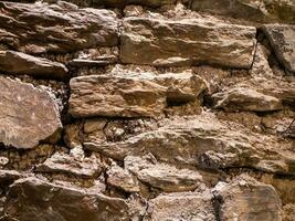 oud steen muur patroon dichtbij visie achtergrond, oude bakstenen oppervlak. natuurlijk rots muur foto