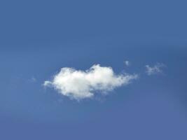 single wit wolk over- blauw lucht achtergrond. pluizig cumulus wolk vorm foto