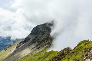 oostenrijks Alpen gedeeltelijk gedekt met wolken Aan een kant en zonneschijn Aan de andere foto