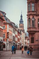 heidelberg, Duitsland - dec 26, 2018 - mensen wandelen in de oud een deel van de stad en de top van de kathedraal Aan de achtergrond foto