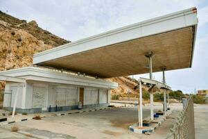 een leeg gas- station met een groot wit gebouw foto