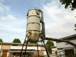 een oud industrieel fabriek met een groot tank foto