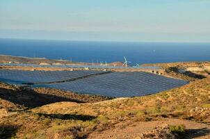 zonne- panelen Aan de kant van een berg met uitzicht de oceaan foto