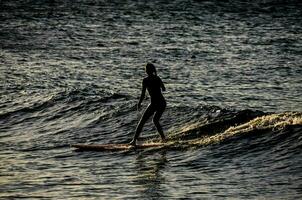 een persoon Aan een surfboard in de oceaan foto