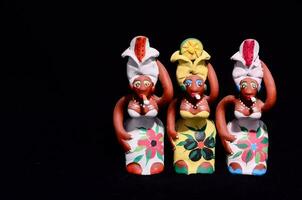 drie beeldjes van Dames Holding bloemen en vervelend kleurrijk kleren foto