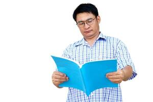 Aziatisch Mens slijtage blauw shirt, bril, houdt boek naar lezen, geïsoleerd Aan wit achtergrond. concept , lezing voor kennis of genoegen. hobby en kom tot rust tijd. ver slechtziend Mens is lezing boek. foto