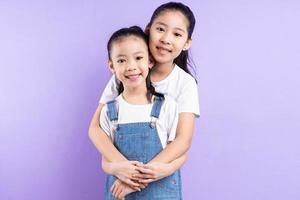 portret van twee Aziatische meisjes op paarse achtergrond foto