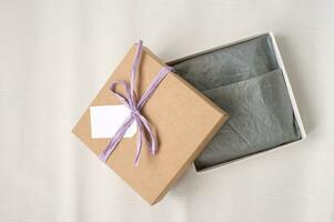Open bruin geschenk plein ambacht doos met lint, mockup label, prijs label. papier voor verpakking kleren foto