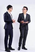 twee Aziatische zakenlieden lopen op witte achtergrond foto