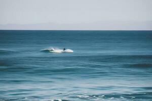 surfer Aan blauw oceaan Golf krijgen loop Bij zonsopkomst. neurale netwerk ai gegenereerd foto