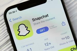 Charkov, Oekraïne - maart 5, 2021 snapchat icoon en toepassing van app op te slaan Aan iphone 12 pro Scherm scherm Aan wit tafel foto